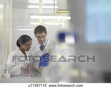Stock Image - Laboratory technicians and petri dishes. Fotosearch
