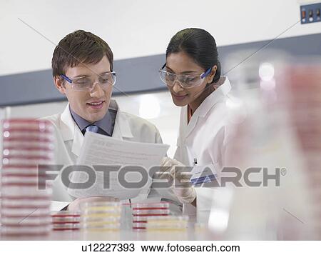 Stock Image - Laboratory technicians with notes. Fotosearch