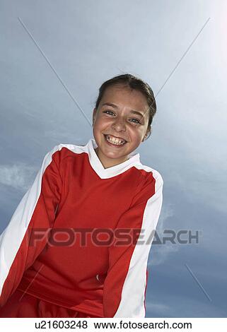 Low viewpoint of young female footballer View Large Photo Image Stock Photo - Low viewpoint of young female footballer. Fotosearch