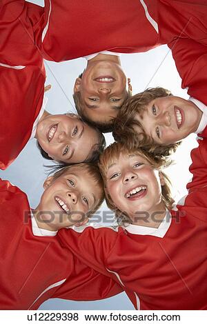 Stock Photo - Low viewpoint of young football team. Fotosearch