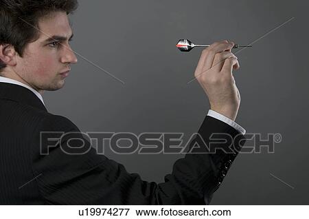 Stock Photo - Male holding dart. Fotosearch