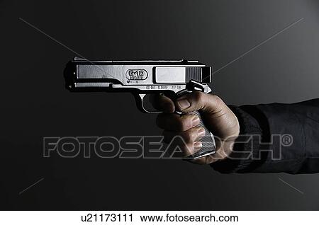 Male holding gun View Large Photo Image Stock Image - Male holding gun. Fotosearch