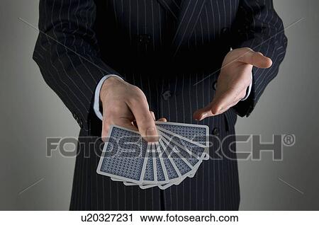 Stock Image - Male holding playing cards. Fotosearch