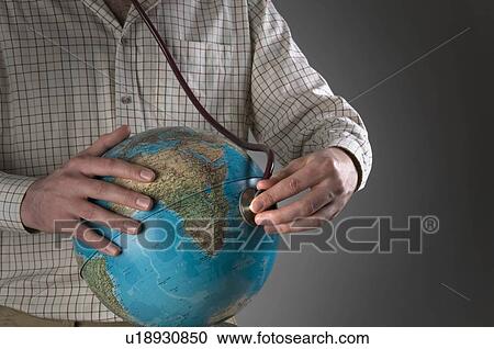 Stock Image - Male holding stethoscope and globe. Fotosearch