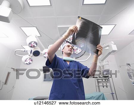 Stock Photo - Male nurse looking at x-ray. Fotosearch