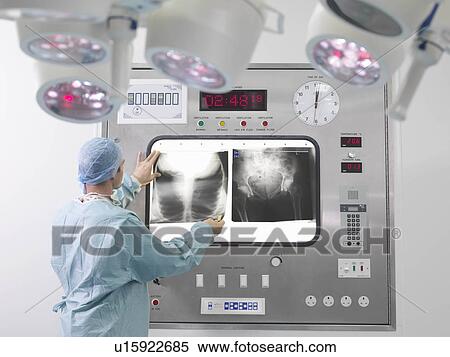 Male surgeon looking at x-rays View Large Photo Image Stock Photography - Male surgeon looking at x-rays. Fotosearch