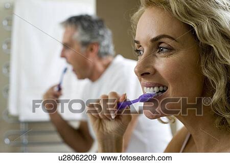 Man and woman brushing teeth View Large Photo Image Stock Photo - Man and woman brushing teeth. Fotosearch