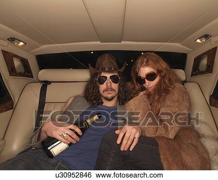 Stock Photograph - Man and woman on backseat of luxury car. Fotosearch