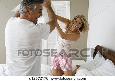 Stock Photograph - Man and woman pillow fighting. Fotosearch