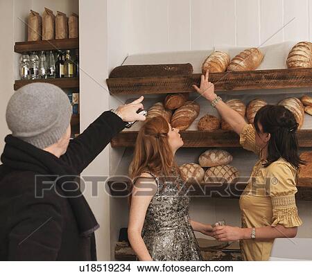 Man and woman pointing at bread on shelf View Large Photo Image Picture - Man and woman pointing at bread on shelf. Fotosearch