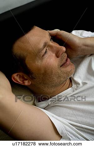 Stock Photo - Man at home with mobile phone. Fotosearch