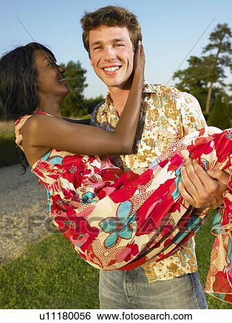 Man carrying woman at sunset View Large Photo Image Stock Photograph - Man carrying woman at sunset. Fotosearch