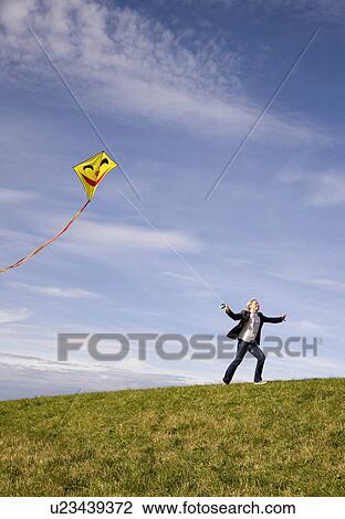 Stock Image - Man flying a kite. Fotosearch