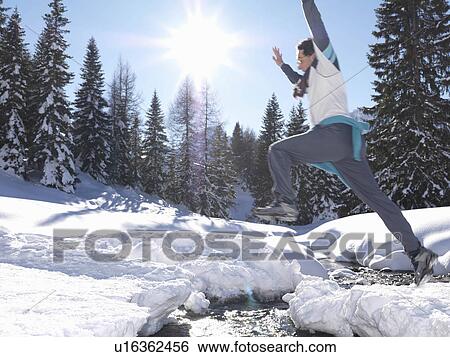 Man jumping across stream View Large Photo Image Stock Photograph - Man jumping across stream. Fotosearch