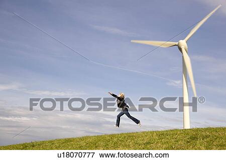 Man jumping in Front of Wind Turbines View Large Photo Image Stock Photo - Man jumping in Front of Wind Turbines. Fotosearch