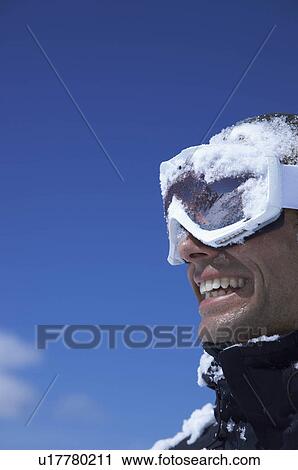 Stock Image - "Man laughing, face covered with snow". Fotosearch