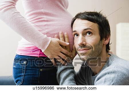 Man listening at wife’s pregnant stomach View Large Photo Image Stock Photograph - Man listening at wife’s pregnant stomach. Fotosearch