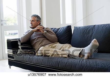 Stock Photo - Man on sofa. Fotosearch