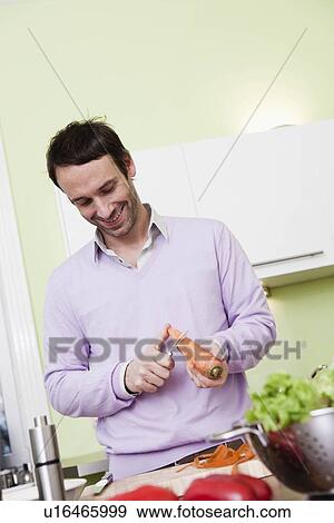 Man peeling a carrot View Large Photo Image Stock Photo - Man peeling a carrot. Fotosearch