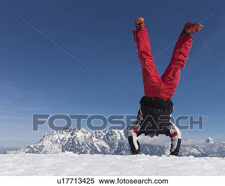 Stock Photography - Man performing handstand on mountain. Fotosearch