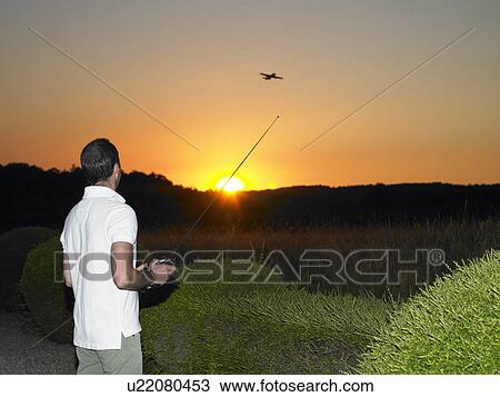 Man playing with remote-controlled plane View Large Photo Image Stock Image - Man playing with remote-controlled plane. Fotosearch
