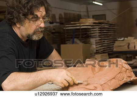 Stock Photo - Man sculpting face in clay. Fotosearch