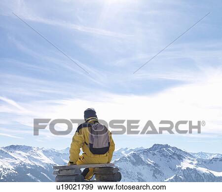 Man sitting on bench on mountain top View Large Photo Image Stock Photo - Man sitting on bench on mountain top. Fotosearch