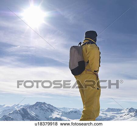 Man standing on mountain top View Large Photo Image Stock Photo - Man standing on mountain top. Fotosearch