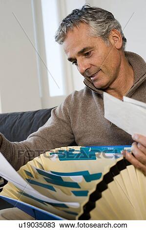 Man with bills at home View Large Photo Image Stock Image - Man with bills at home. Fotosearch