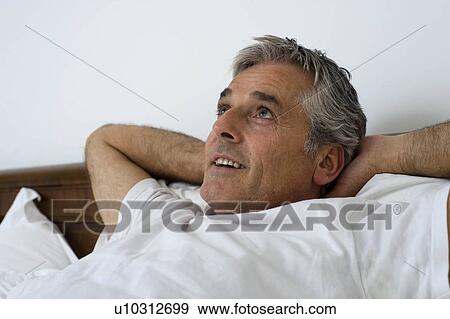 Stock Photo - Man with hands behind head. Fotosearch