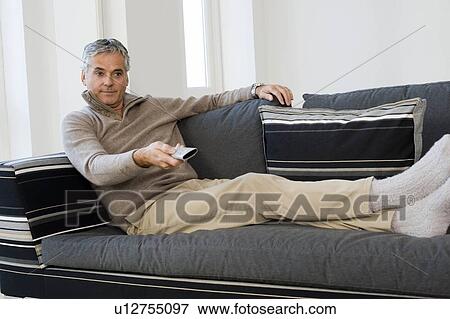 Man with TV remote View Large Photo Image Stock Photo - Man with TV remote. Fotosearch