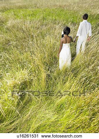 Married couple walking in a field View Large Photo Image Stock Image - Married couple walking in a field. Fotosearch
