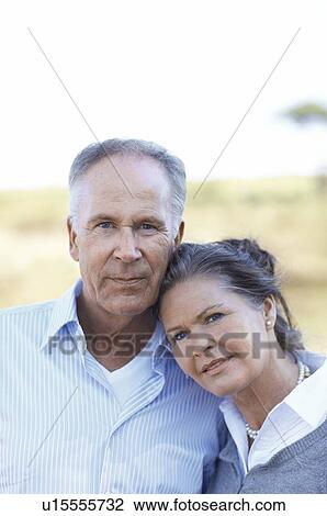 Stock Image - Mature couple standing close together. Fotosearch