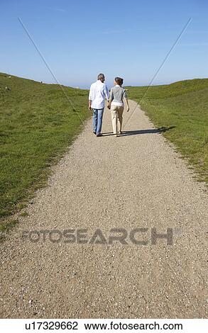 Stock Image - Mature couple walking away together. Fotosearch