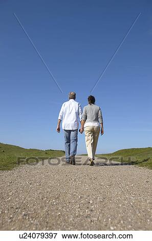 Mature couple walking away together View Large Photo Image Stock Photo - Mature couple walking away together. Fotosearch