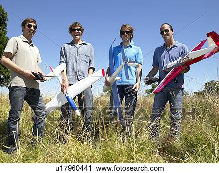 Stock Image - Men with remote-controlled plane. Fotosearch