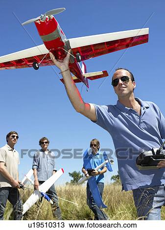 Stock Image - Men with remote-controlled plane. Fotosearch