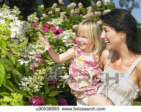 Stock Image - Mother and daughter looking at flowers. Fotosearch