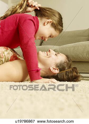 Mother and daughter lying on floor View Large Photo Image Stock Photo - Mother and daughter lying on floor. Fotosearch