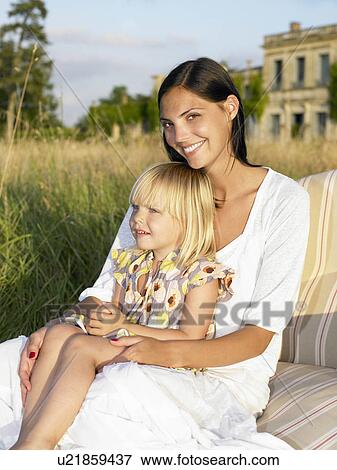 Mother and daughter on sofa in a field View Large Photo Image Stock Photo - Mother and daughter on sofa in a field. Fotosearch