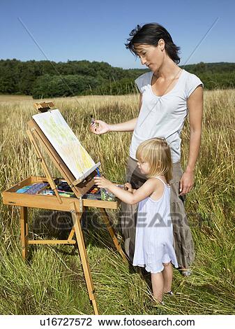 Mother and daughter painting in a field View Large Photo Image Stock Image - Mother and daughter painting in a field. Fotosearch