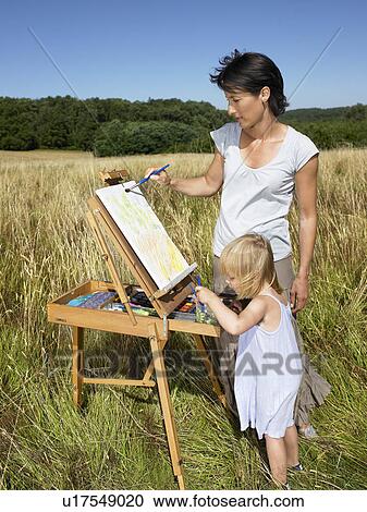 Mother and daughter painting in a field View Large Photo Image Stock Image - Mother and daughter painting in a field. Fotosearch