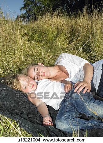 Mother and daughter sleeping in a field View Large Photo Image Picture - Mother and daughter sleeping in a field. Fotosearch