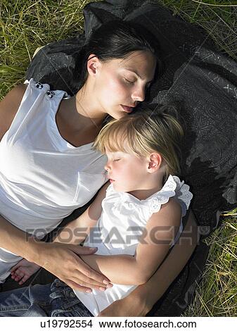 Picture - Mother and daughter sleeping in a field. Fotosearch