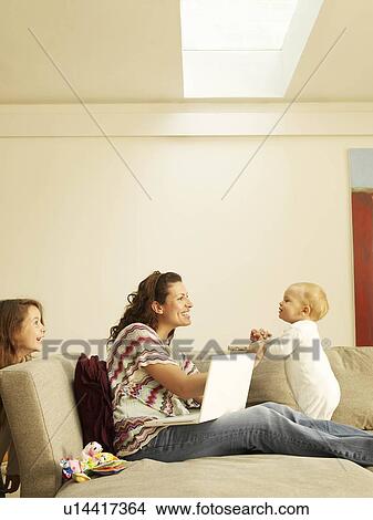 Picture - Mother and girl playing with baby. Fotosearch
