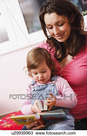 Stock Image - Mother and her baby reading book. Fotosearch