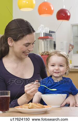 "Mother feeding young girl, happy" View Large Photo Image Stock Image - "Mother feeding young girl, happy". Fotosearch