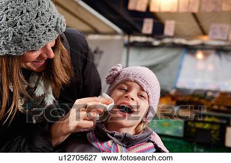 Stock Photo - Mother wiping daughter's mouth. Fotosearch