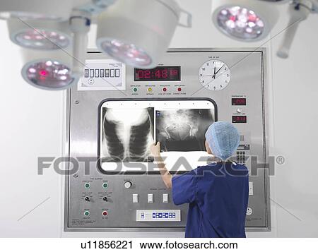 Stock Image - Nurse with x-rays in operating theatre. Fotosearch