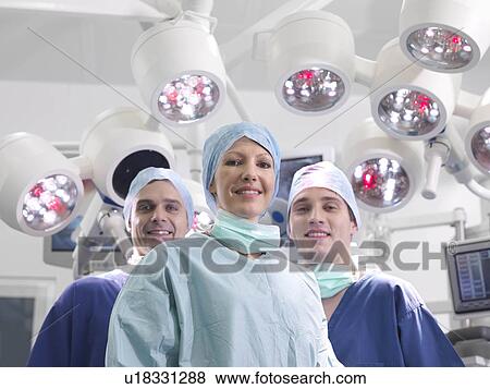 Stock Photo - Nurses and female surgeon in theatre. Fotosearch